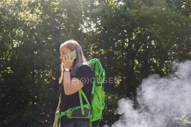Young woman talking on phone in meadow — Stock Photo