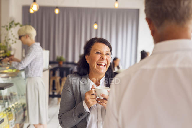 Senior man and mature woman laughing in cafe — Stock Photo