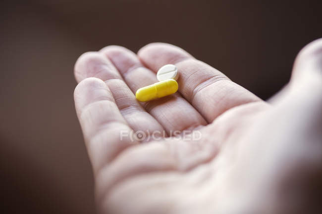 Close-up de mão segurando pílulas — Fotografia de Stock