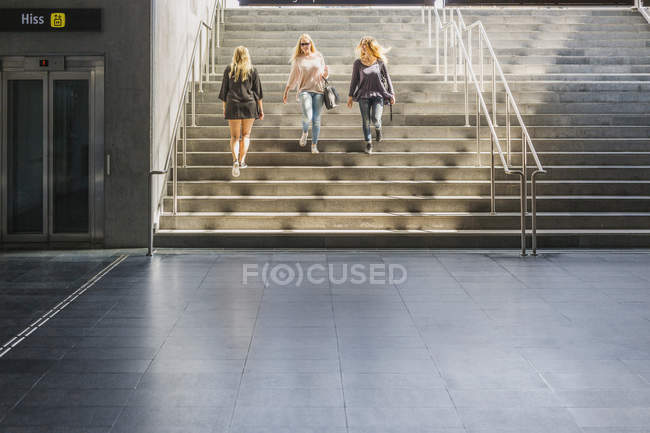 Mujeres caminando por las escaleras desde abajo - foto de stock