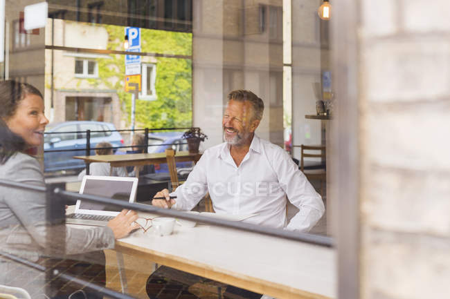 Hombre mayor y mujer madura hablando en la cafetería - foto de stock