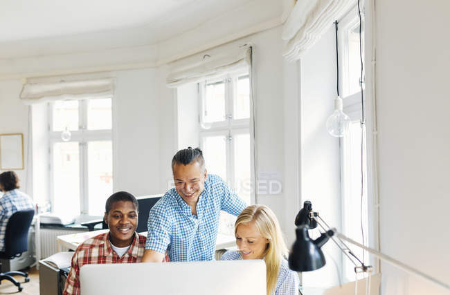 Editors using computer together in office — Stock Photo