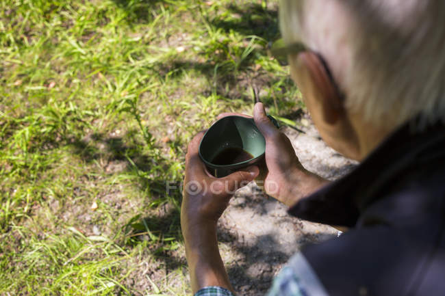 Чоловік тримає чашку над землею — стокове фото