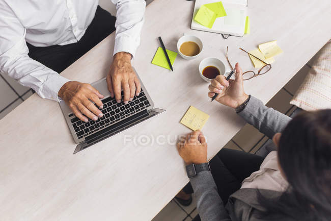 High angle view of senior man and mature woman working in cafe — Stock Photo