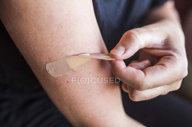 Close-up of man removing bandage — Stock Photo