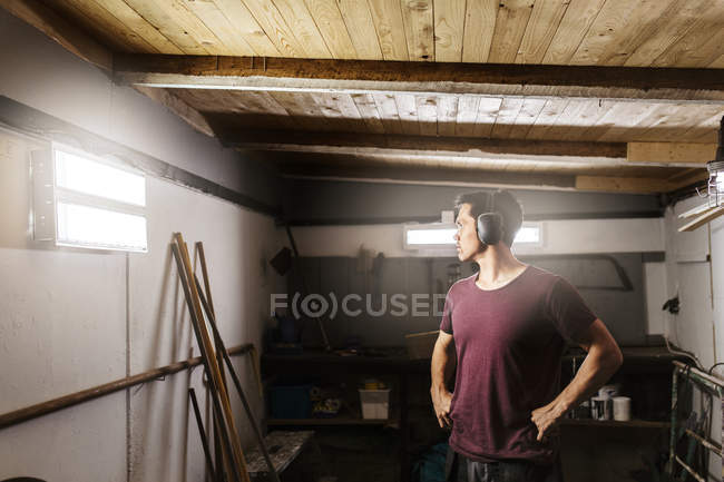 Man wearing ear muffs in garage — Stock Photo