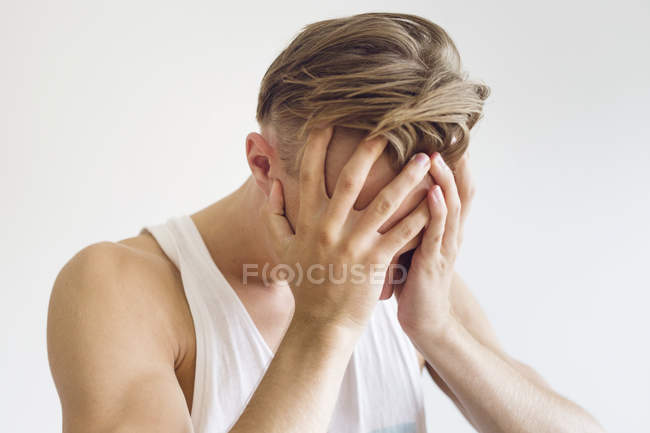 Jeune homme pensif avec la tête dans les mains — Photo de stock
