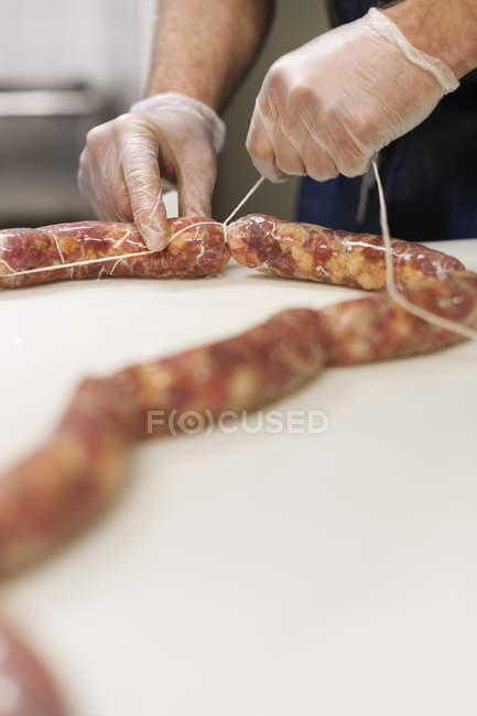 Крупный план человека, делающего свиные колбаски — стоковое фото