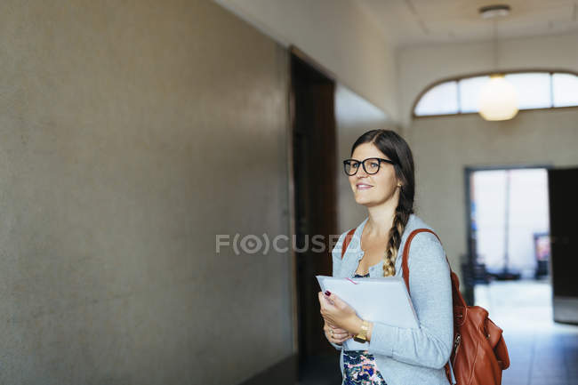 Woman holding documents in corridor — Stock Photo