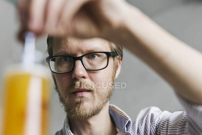 Brewery worker examining beer in beaker — Stock Photo
