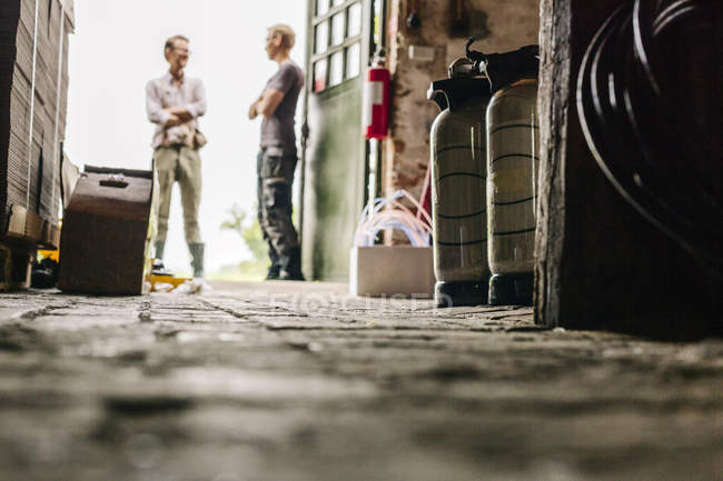 Due operai che parlano nel birrificio locale — Foto stock