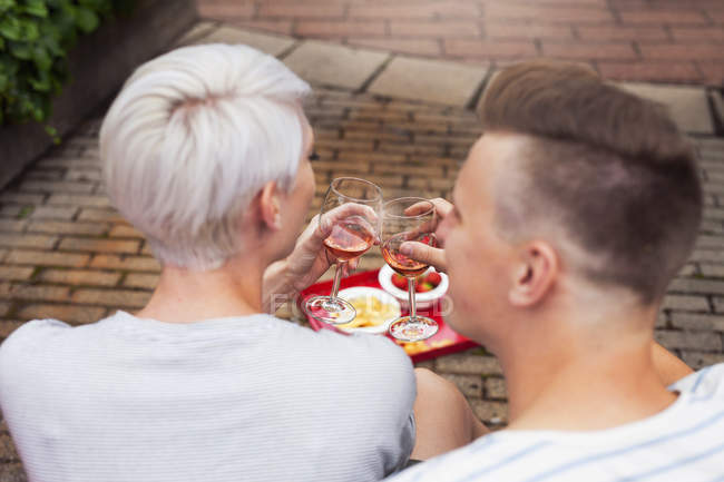 Vue arrière du couple levant un toast dans le jardin — Photo de stock