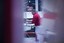 Homme travaillant dans une usine industrielle — Photo de stock