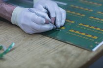 Trabalhador em luvas trabalhando na placa do condutor — Fotografia de Stock