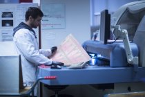 Людина в лабораторному пальто на робочому місці — стокове фото
