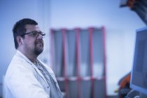Людина в лабораторному пальто на робочому місці — стокове фото