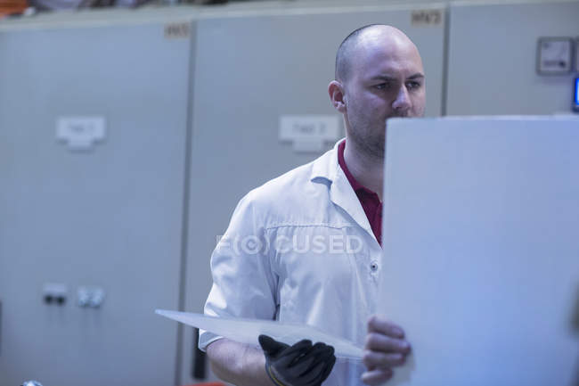 Чоловік в лабораторному пальто розмовляє з колегою — стокове фото