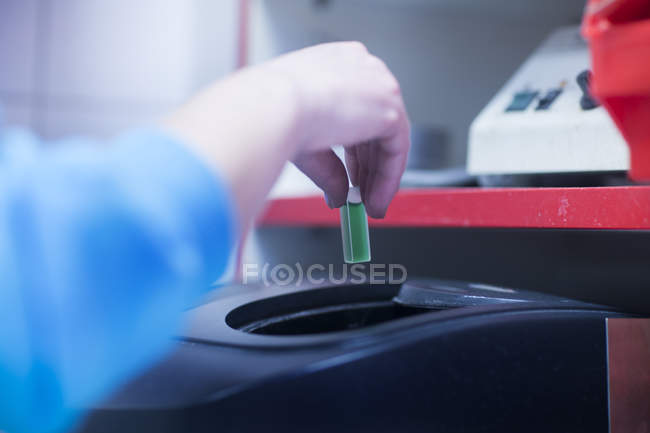 Worker putting chemical mixture in machine — Stock Photo