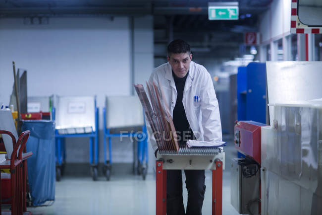Employee moving equipment at industrial plant — Stock Photo