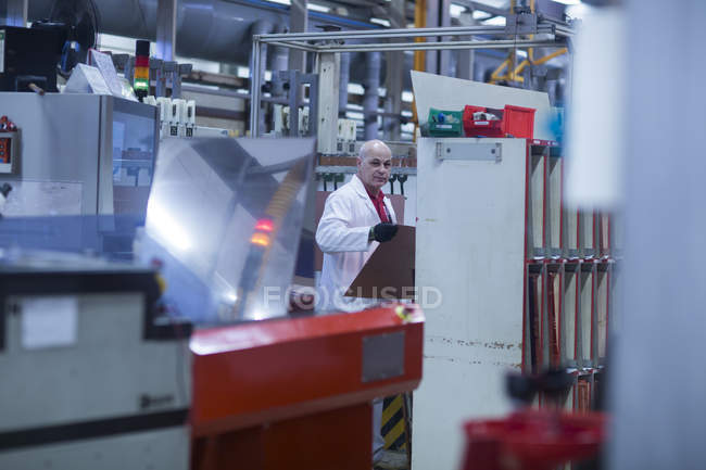 Hombre trabajando en una planta industrial - foto de stock
