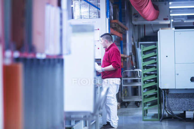 Молодой человек, работающий на заводе — стоковое фото