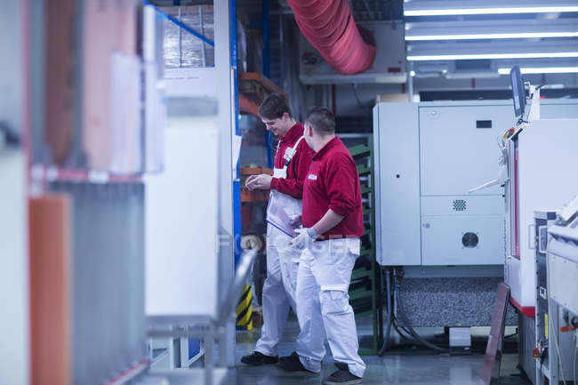 Два рабочих разговаривают на промышленном заводе — стоковое фото