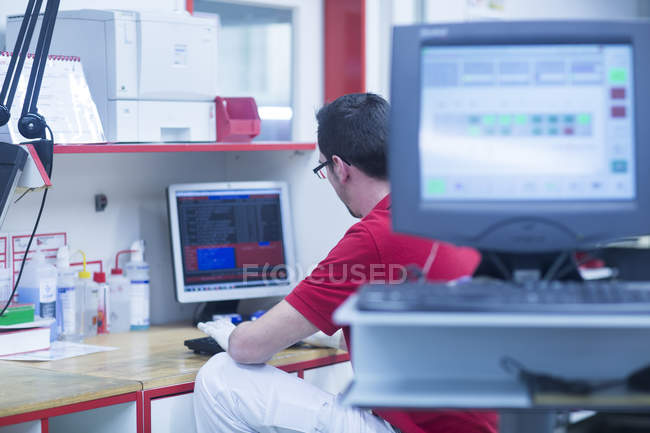Чоловік працює на комп'ютері на заводі — стокове фото