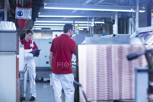 Male colleagues working at factory — Stock Photo