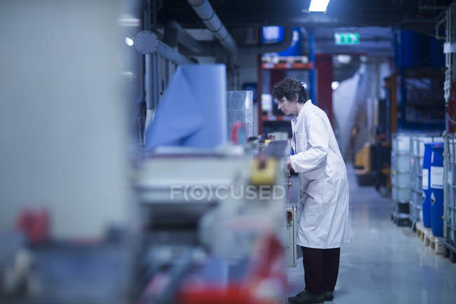 Жінка перевіряє обладнання на промисловому заводі — стокове фото