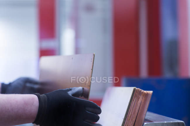 Travailleur dans des gants démontrant le panneau conducteur — Photo de stock