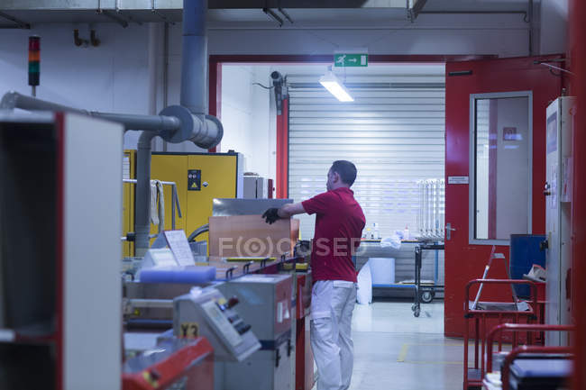 Homme travaillant dans une usine industrielle — Photo de stock
