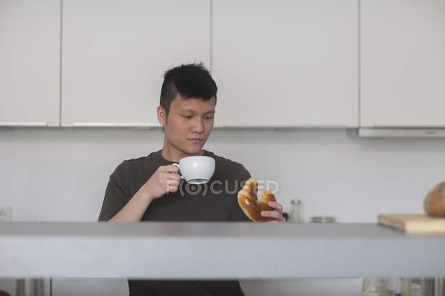 Mann trinkt Tee mit Brötchen — Stockfoto