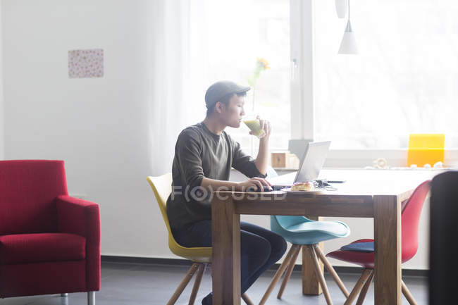 Man working on laptop computer at home — Stock Photo