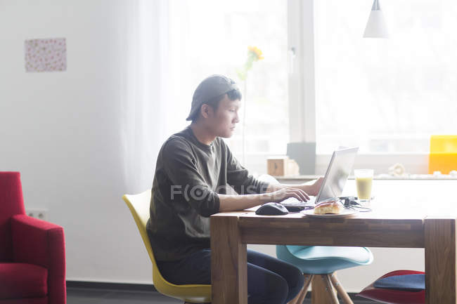 Мужчина работает на ноутбуке дома — стоковое фото