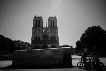 Gente en bicicleta frente a Notre Dame de Paris - foto de stock