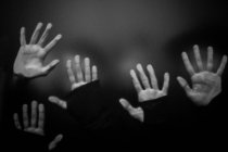 Hands of models on transparent surface — Stock Photo