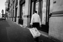 Homem andando na calçada com saco na mão — Fotografia de Stock