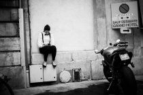Офіціант дівчина сидить на парапету і за допомогою смартфона — стокове фото