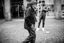 Homem caminhando perto músico — Fotografia de Stock