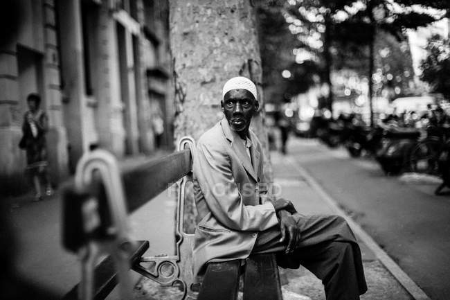 Afrikanischer alter Mann sitzt auf Bank — Stockfoto