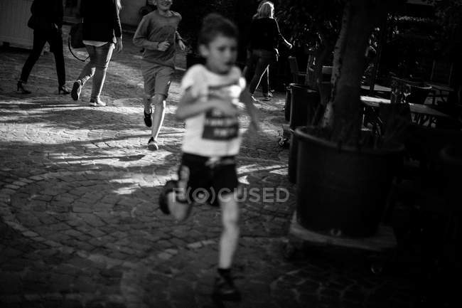 Два мальчика бегут по городской улице — стоковое фото