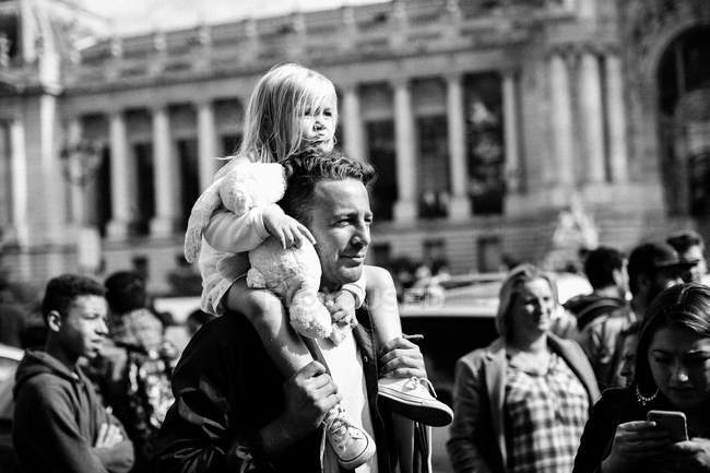 Padre con hija sentada sobre hombros - foto de stock