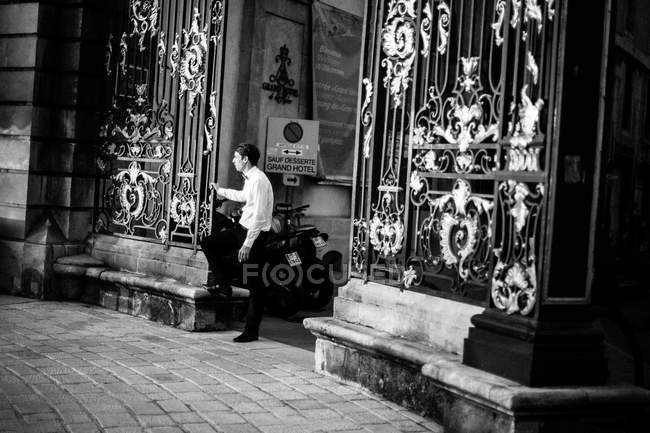 Bellboy de pé na frente dos portões — Fotografia de Stock