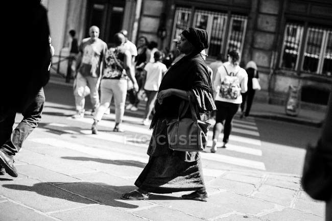Frau läuft in schwarzem Kleid auf Straße — Stockfoto