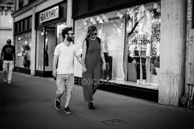 Homme et femme marchant dans la rue — Photo de stock
