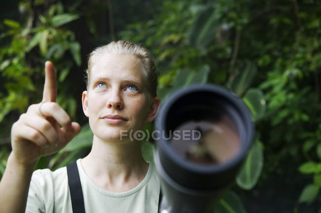 Mujer bonita con telescopio en la selva tropical - foto de stock