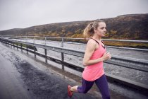 Mujer corriendo por el puente - foto de stock