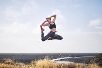 Женщина прыгает по безлюдной невозделанной дороге — стоковое фото