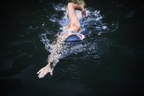 Femme nageant dans la piscine extérieure — Photo de stock