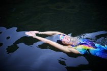 Femme nageant dans la piscine extérieure — Photo de stock